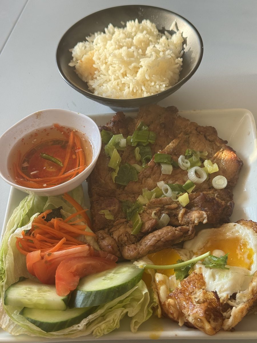 Marinated pork chop with two fried eggs, rice, cucumber and pickled carrots